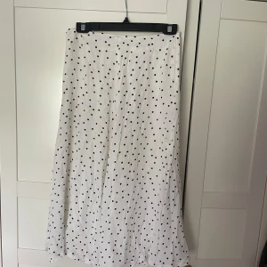 Vit långkjol med svarta prickar - Supersöt långkjol i vitt med svarta prickar.