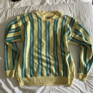 Retro tröja🤩 - Retro stickad tröja från Loop i gult med vertikala ränder i grått/lila och turkost. Broderad Loop-logga nertill.Fint skick!❤️