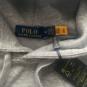 Grå hoodie från Polo Ralph Lauren - Snygg grå hoodie från Polo Ralph lauren✅ väldigt bra skick👍 skickar snabbt efter ägg du har beställt. Liten i storlek passar S