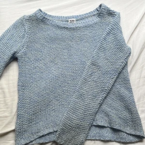 Ljusblå stickad tröja från Vero Moda - Supermysig ljusblå stickad tröja från Vero Moda. Tröjan har en avslappnad passform, rund halsringning och långa ärmar. Perfekt att slänga på sig när det är lite kyligt ute. Enkel och stilren design som funkar till det mesta.
