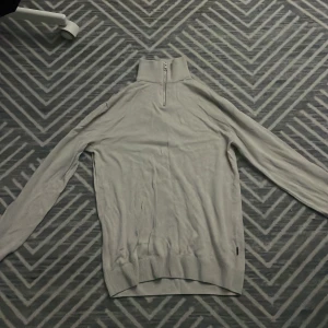 Beige half zip tröja Jack & Jones - Snygg beige långärmad tröja från Jack & Jones med half zip-dragkedja i halsen. Tröjan har en hög krage och är tillverkad i mjukt material som känns skönt mot huden. Perfekt för lager-på-lager och enkel att matcha med jeans eller chinos.PRIS KAN DISKUTERAS 