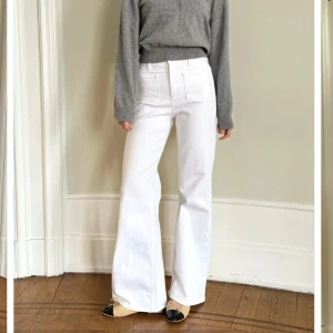 Vita wide jeans med hög midja - Säljer ett par fräscha vita jeans med hög midja och breda ben. Byxorna har raka, vida ben och stora fickor framtill. Perfekta för en clean och trendig look. Passar dig som gillar stilrena och bekväma byxor. Från Sanne Alexandra, använda en gång, nypris 995 kr