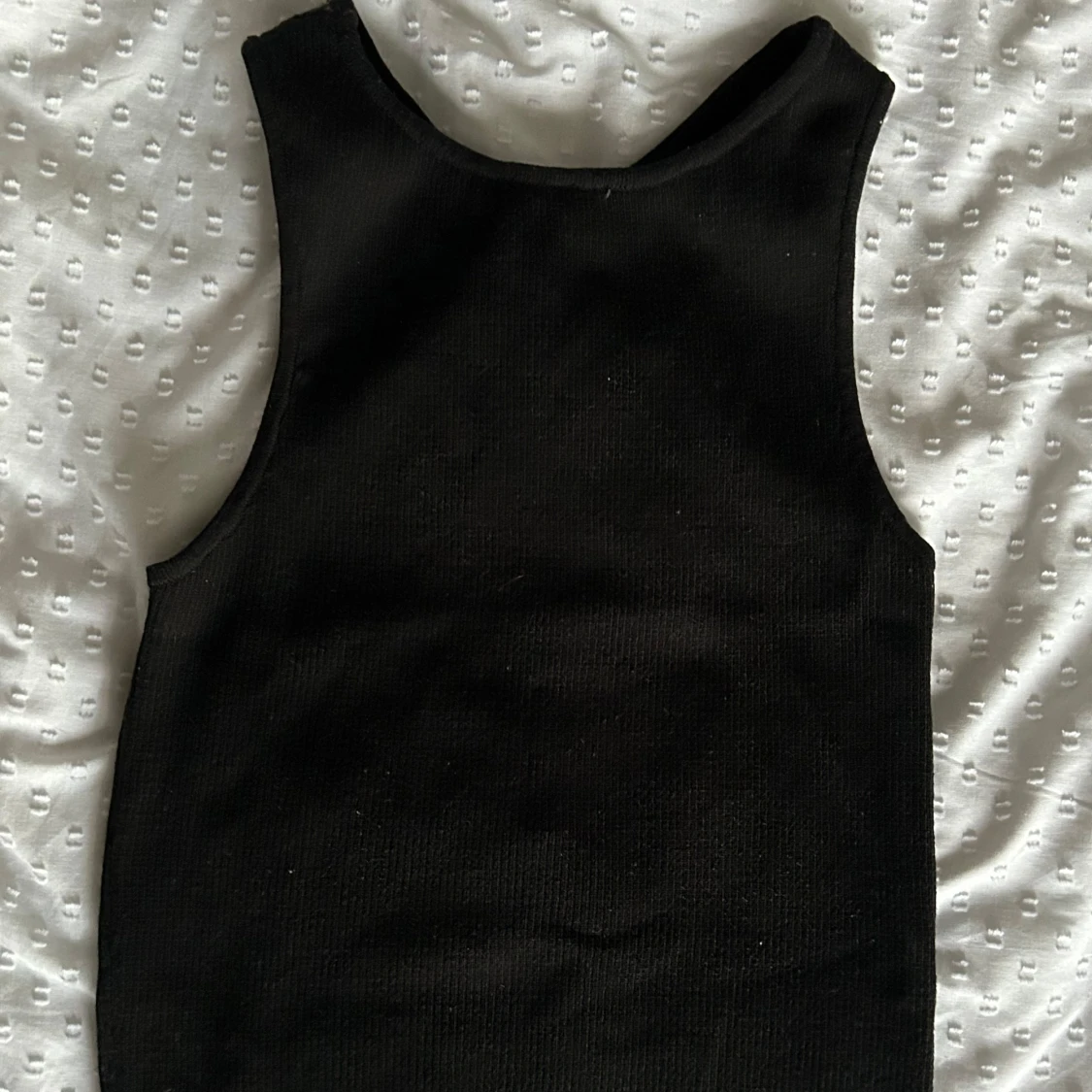 Svart ribbad linnetopp med korsad rygg