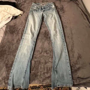 Ljusblå bootcut jeans från Fishbone - Säljer ett par ljusblå lågmidjade bootcut jeans från Fishbone med dragkedjor på bakfickorna! Är omsydda till bootcut som börjat gå upp liteee men går enkelt att fixa. Midjemått 33 & Innerbenslängd 80