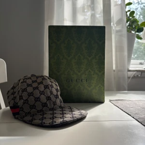 gucci keps  - Säljer denna snygga gucci keps pågrund av att den inte används längre. Den är i väldigt bra skick och boxen följs med, dm för mer information.