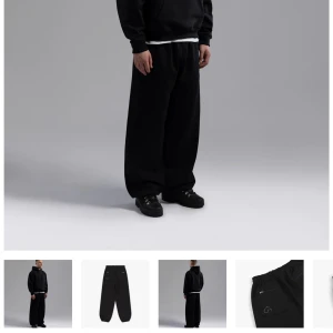 Svarta wide mjukisbyxor Garms Affiliated - Svarta mjukisbyxor från Garms Affiliated med elastisk midja. Byxorna har två bakfickor med dragkedja helt nya i paketet