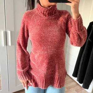 Rosa polotröja i chenille - Mysig rosa polotröja i mjuk chenille med ribbade muddar och hög krage. Väldigt mjuk, perfekt till hösten och vintern. Använd ett fåtal gånger, kommer i mycket bra skick. 