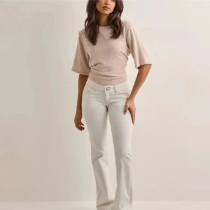 Vita bootcut jeans med kontrastsömmar från Nelly - Snygga vita jeans med bootcut-silhuett och coola kontrastsömmar på bakfickorna. Byxorna har klassisk femficksdesign, normal midja och är tillverkade i ett stretchigt jeanstyg som sitter skönt. Jeansen är lite slitna nere i änden men annars i bra skick på dom. Lägger ut dom för lite intresse kontroll så det är bara att skiva om du är intresserade!