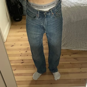 Levi's 501 blå jeans straight fit - Ett par Levis jeans, Stay Loose, blå tvätt med straight fit. Materialet är slitstarkt denim i bomull och passformen är normal med raka ben. Jeansen är uppsydda till strlk 32/32. Innan 32/34 Nypris: 1300 kr