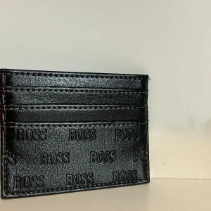 Svart kortfodral  - Snyggt svart kortfodral. Fodralet har flera kortfack och stilren design som passar perfekt i fickan. Perfekt accessoar för dig som vill ha koll på korten med stil.