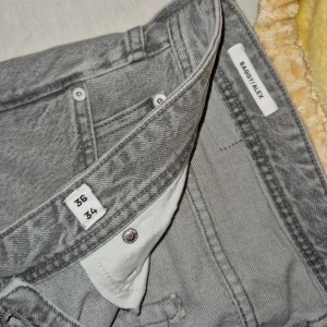 Grå baggy jeans från Jack & Jones - Säljer ett par gråa baggy jeans från Jack & Jones med klassisk femficksdesign och knäppning med knappar. Jeansen har bred passform och raka ben, perfekt för en avslappnad stil. Materialet är robust denim i bomull.