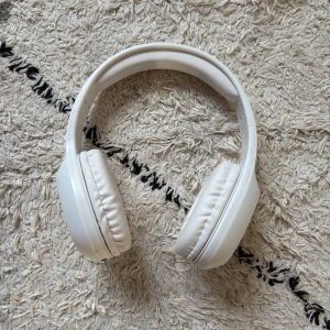 Vita trådlösa hörlurar med laddare - Vet tyvärr inte vart dom är ifrån tror jag fick dom när jag sålde jultidningarna för ett år sedan men minns ej märket men laddare och instruktioner medföljer