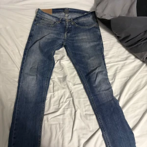 Blå jeans från Dondup, storlek 31 - Säljer ett par snygga blå jeans från Dondup i storlek 31. Klassisk femficksmodell med knappgylf och kontrastsömmar. Jeansen har en rak passform och är tillverkade i slitstarkt denimtyg. Perfekt för dig som gillar stilrena och tidlösa jeans.