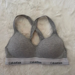 BRALETTE LIFT - Bh-linnen - calvin klein - Grå bh från Calvin Klein med brottarrygg och bred resår med logga. Mjuk bomullsblandning och sportig look, perfekt för chill eller träning. Snygg och enkel design med vit och svart detalj nertill.