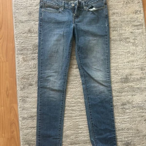 Levi's 511 skinny jeans blå denim - Snygga Levi's 511 skinny jeans i klassisk blå denim. Modellen har smal passform, fem fickor och dragkedjegylf. Typisk Levi's-detalj med röd etikett på bakfickan och läderpatch i midjan. Perfekta till sneakers eller boots.