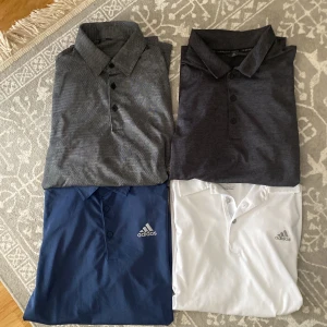 Adidas pikétröjor i olika färger - Fyra snygga pikétröjor från Adidas i färgerna vit, marinblå, mörkgrå och grå. Alla har klassisk krage, knappar framtill och Adidas-logga på bröstet. Den vita har även tre silverfärgade ränder på ryggen. Perfekt för sport eller chill häng. De är lite olika storlekar men alla passar jättebra för dig som har S