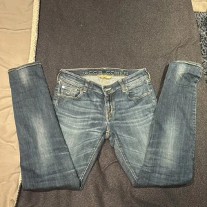 Jacob Cohën Jeans - Snygga blå jeans från Jacob Cohën med klassisk femficksdesign och guldfärgade sömmar. Jeansen har en rak passform och är tillverkade i mjukt denim med diskret tvättad look. Broderad J på myntfickan och logga bak på linningen.