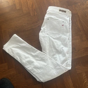 Unika jeans från Replay med slitningar - Säljer ett par snygga vita jeans från Replay med en stilren design. Byxorna har en slim passform. Byxorna har slitningar och är i storlek W27 L30 (liten i storleken) Säljer på grund av att de är för små för mig. Passar bäst på 160-168. Väldigt bra skick.