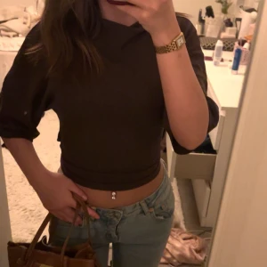 Brun omlottopp - Snygg brun omlottopp med trekvartsärm och knytning i ryggen. Perfekt för en stilren look. Passar bra till jeans eller kjol.
