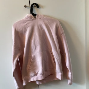 Ljusrosa hoodie från Gina Tricot - Säljer en ljusrosa hoodie från Gina Tricot, perfekt för en avslappnad stil. Den har en klassisk design med en stor ficka framtill och en bekväm huva. Perfekt för kyliga dagar eller mysiga hemmakvällar. 💖