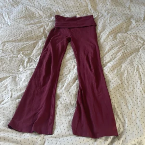 Vinröda byxor med utsvängda ben - Snygga vinröda byxor med utsvängda ben och hög midja, går att vika ner som yoga pants. Perfekta för en trendig look. Tillverkade i ett mjukt och bekvämt material. Från Lindex och har ett lite hål vid rumpan som inte alls syns. Pris kan diskuteras. 
