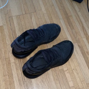 Svarta Nike Air Max sneakers - Säljer ett par svarta Nike Air Max sneakers med snörning. Skorna har en rund tå och en bekväm sula, perfekt för vardagsbruk. De är stilrena och passar till det mesta i garderoben. Skorna är slitna och trasiga. Dessutom har skorna punkterande och innehåller stenar, då det finns hål under dem.