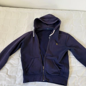 Mörkblå hoodie från Ralph Lauren - Säljer en snygg mörkblå hoodie från Ralph lauren. Den är i storlek m men skulle säga att den även passar L. Bra skick o skönt material.