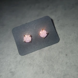 Rosa örhängen - Säljer ett par stilrena örhängen med rosa stenar. Perfekta för att ge en subtil färgklick till din outfit.
