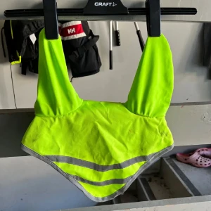 Neongul reflexhuva - Säljer en neongul reflexhuva i storlek full. Huvan har reflekterande ränder för extra synlighet och är perfekt för utomhusaktiviteter. 