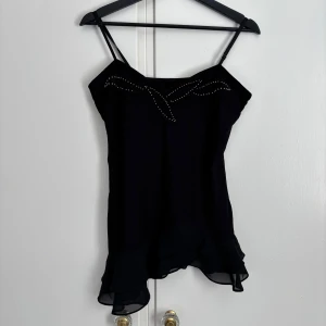 Svart topp - Ett snyggt svart linne med tunna axelband och volangdetaljer i nederkant. Köpte här på plick men kommer inte till användning. Står inget märke eller storlek men skulle säga att den känns som S-M🖤