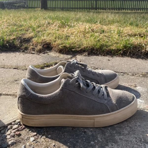 Grå mockasneakers från Vagabond - Snygga grå sneakers i mocka från Vagabond. De har en klassisk design perfekt för sommarn. Skick 8/10 storlek 43 pris 399kr hör av er vid några funderingar!