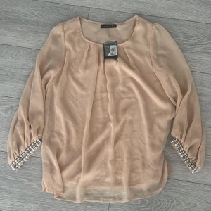 Blus med pärlor på armar  - Ny blus med prislapp med fina pärlor och stenar 