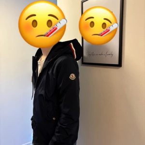 Marinblå vindjacka från Moncler - Säljer en stilren marinblå vindjacka från Moncler. Jackan har en dragkedja framtill och en justerbar huva. Perfekt för vår och höst med sin lätta och funktionella design. Moncler-loggan syns tydligt på ärmen. Skick 9/10 inga defekter. Använd fåtal gånger