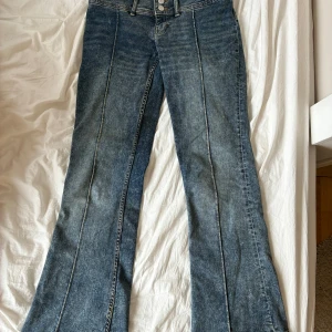 Monki jeans - Jättesnygga lowwaist, bootcut jeans från monki! De är köpta secondhand men i väldigt gott skick(endast uppsprättade längst ner)💕måtten är 39cm tvärsöver, och 80 cm innerbenslängd