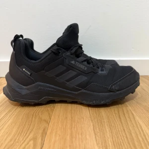 Svarta Terrex sneakers från Adidas - Säljer ett par svarta Adidas Terrex sneakers. Skorna har en robust design med snörning och är perfekta för utomhusaktiviteter. De har en slitstark sula och är gjorda i syntetmaterial för extra hållbarhet.