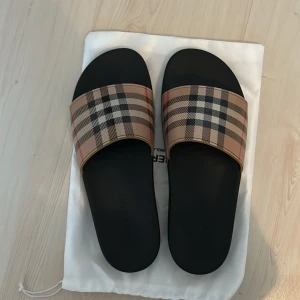 Burberry tofflor - Dessa tofflor är i storlek 43 de är väldigt bekväma och snygga. Har använt de ungefär 2 gånger men de är i väldigt bra skick. Pris går absolut att diskutera.