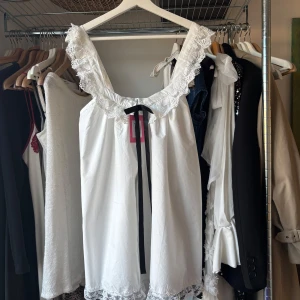 Vit klänning med spetsdetaljer - Säljer en vacker vit klänning med spetsdetaljer runt halsringningen och fållen. Väldigt fin till sommaren och va planerad att ha på studenten men blev aldrig använd tyvärr. Lite i babydoll stil på klänningen och verkligen så söt!🩷