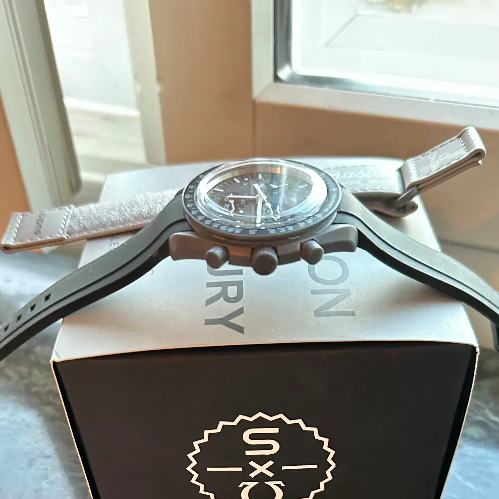 Säljer en Omega x Swatch Speedmaster med svart urtavla och svart armband. Klockan har en klassisk design med tydliga markeringar och en stilren look. Perfekt för den som gillar tidlös elegans.. Asusteet.