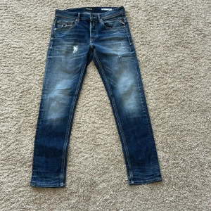 Blå jeans från Replay - Säljer ett par snygga replay jeans med slitningar i modellen willibi (slim fit) storlek w27 l30. Nypris ligger runt 1899kr