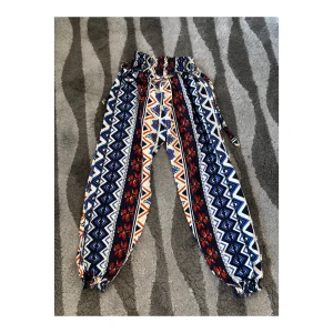 Tygbyxor i 90-tals mönster, strl S/M - Tunna tygbyxor (liknar harembyxor) i storlek S/M. SAMFRAKTAR om du köper flera varor samtidigt! 📦