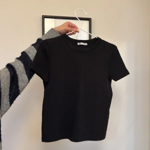 Svart kortärmad t-shirt från Zara - Säljer en stilren svart t-shirt från Zara som är använd 1 gång! 