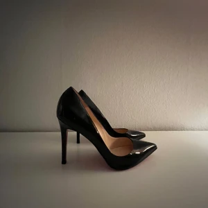 Christian Louboutins Iriza pumps  - Eleganta svarta pumps med hög klack och spetsig tå. Perfekta för en stilren look. Skorna har en klassisk och tidslös design. Slittning på botten av klackarna, går att måla om eller fylla över!☺️Har bevis på att dom är äkta!