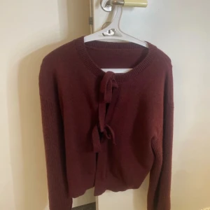 Vinröd kofta med knytband - Jättefin långärmad stickad tröja som man kan göra två knutar på och öppna de om man vill och styla den på många olika sätt! Använt den en enstaka gång och köpt den från shein. Jätte skönt material men har enkelt att bli elektriskt när man tar på sig den annars är den perfekt och felfri💞 priset går alltid att diskutera😇