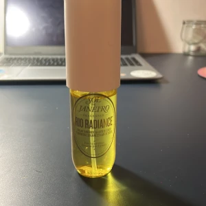 Sol de Janeiro Rio Radiance Parfym - Fräsch och exotisk doft från Sol de Janeiro, Rio Radiance. Parfymen kommer i en genomskinlig gul flaska med en vit spraykork. Perfekt för att ge en känsla av sommar och sol.