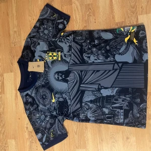 Barazill fotbollströja från Nike - Snygg fotbollströja från Nike med ett unikt mönster i grått och gult. Tröjan har korta ärmar och en cool design med detaljer som verkligen sticker ut. Perfekt för fotbollsälskaren som vill ha något annorlunda på planen.