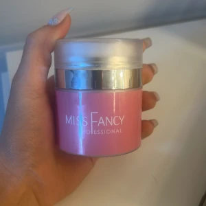 Rosa gelé från Miss Fancy - En rosa gelefrån Miss Fancy i en rund burk med silverlock. Gelén har en ljusrosa nyans och kommer i en stilren förpackning. Perfekt för att ge naglarna en fräsch känsla. Använd till 2 set
