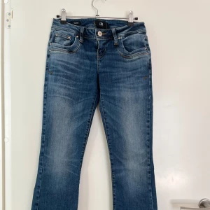 Blå jeans från LTB. Modell Valerie. - Snygga blå jeans från LTB med klassisk femficksdesign och knappgylf. Jeansen har en lätt tvättad look och är perfekta för en avslappnad stil. De har en normal passform och är tillverkade i ett bekvämt denimtyg. Storlek:W26/L30.