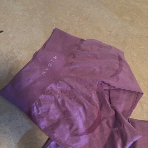 Rosa leggings från NVGTN - Säljer ett par snygga rosa tights  från NVGTN. De är tillverkade i ett stretchigt material som ger en bekväm passform. Perfekta för träning eller en avslappnad dag hemma. Högmidjade för extra komfort och stil.