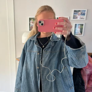 Blå jeansjacka - Säljer en klassisk blå jeansjacka med normal passform. Jackan har långa ärmar och knappar framtill. Perfekt för vår och sommar o höst 