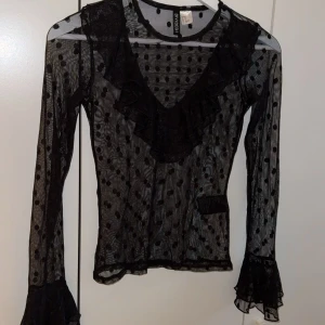 Svart topp - Svart långärmad sheer topp med söta volanger. Stl xs. Hör av er för fler bilder!